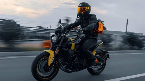 Letbe Arthur 700 2026 – Fahraufnahme mit Fahrer in schwarzer Motorradkleidung bei Daemmerung, Naked Bike in Schwarz-Gelb in Bewegung