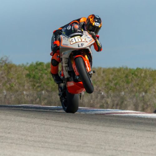Lightfighter V3-RS 2026 – Fahrer #36x beim Wheelie am COTA (Circuit of the Americas) in Dainese-Kombi mit Orange-Cat-Lackierung
