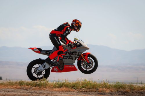 Lightfighter V3-RS 2026 – Fahrer #36x beim spektakularen Wheelie uber Kuppe auf Thunderhill Raceway mit Bergen im Hintergrund