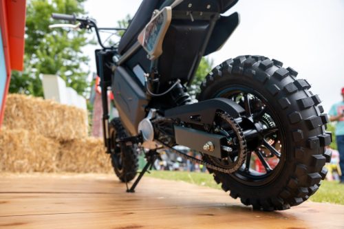 LiveWire S4 Honcho 2026 in Grau-Türkis – Frosch­perspektive der Heckpartie mit grobstolligem Hinterreifen und Kette auf einem Holzdeck