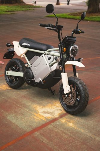 LiveWire S4 Honcho Trail 2026 in Weiß-Grau – Front-Dreiviertelansicht auf einem Stadtplatz mit rundem LED-Scheinwerfer und Stollenreifen