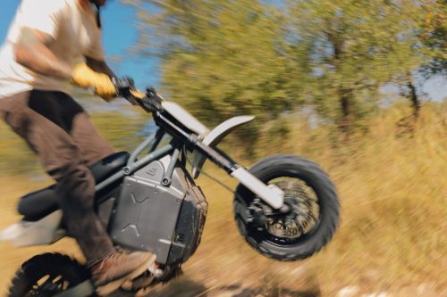 LiveWire S4 Honcho Trail 2026 in Weiß-Grau – Fahrer hebt im Gelände das Vorderrad an, dynamische Aufnahme mit Bewegungsunschärfe