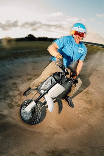 LiveWire S4 Honcho Trail 2026 in Weiß-Grau – Fahrer in blauem Shirt driftet auf Sandboden, dynamische Aufnahme