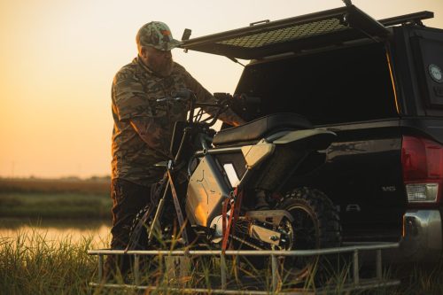 LiveWire S4 Honcho Trail 2026 – Jäger in Camo verlädt das schlammige Minibike auf die Ladefläche eines Pick-ups bei Sonnenuntergang