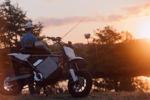 LiveWire S4 Honcho Trail 2026 in Weiß – Front-Dreiviertelansicht mit Angelrute, Mann am Seeufer bei Sonnenuntergang