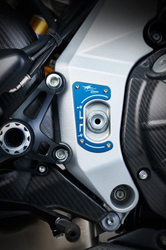MV Agusta Rush Titanio – Detail Rahmen-Schwingenlager mit blauer CNC-gefrästter Abdeckplatte und MV Agusta-Logo, Carbon-Verkleidung