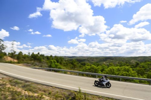 Norton Manx R Signature 2026 – Fahrer auf Landstraße in Andalusien mit weitem Panoramablick über grüne Hügellandschaft
