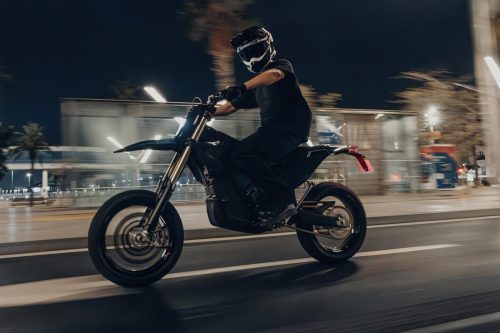 Stark VARG SM Sköll 2026 – Fahrer in schwarzer Montur in schneller Fahrt durch nächtliche Stadtstraße, Bewegungsunschärfe im Hintergrund