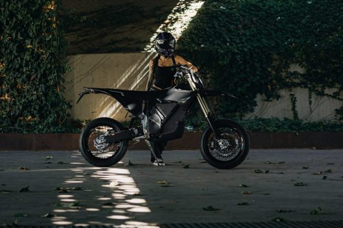 Stark VARG SM Sköll 2026 – Fahrer steht mit dem Motorrad an einer efeubewachsenen Mauer im Streiflicht