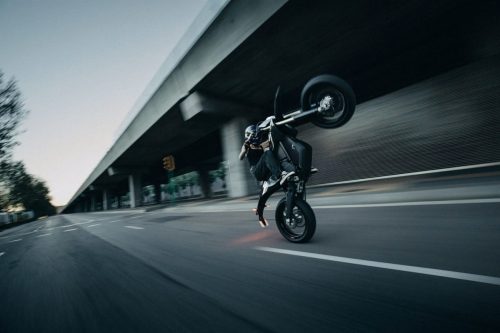 Stark VARG SM Sköll 2026 – Wheelie auf einer Straße unter einer Brücke, Bewegungsunschärfe der Umgebung