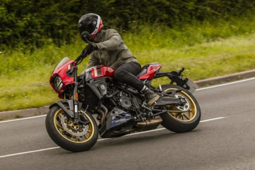 Suzuki GSX-8TT 2027 in Candy Daring Red mit goldenen Felgen in Schräglage auf einer Landstraße