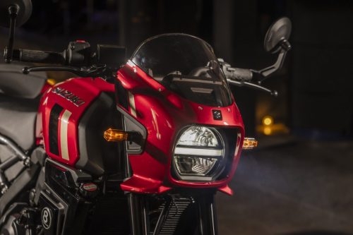 Suzuki GSX-8TT 2027 – Frontdetail mit LED-Scheinwerfer, Lampenmaske in Candy Daring Red und Blinkern in dunkler Umgebung