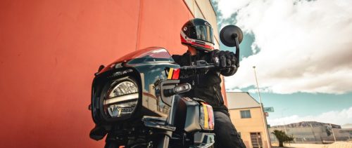 Suzuki GSX-8TT – Fahrer am Lenker, Blick auf Lampenmaske und LED-Scheinwerfer vor roter Hauswand