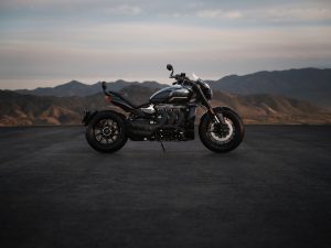 Triumph Rocket 3 Storm GT 2027 – Seitenansicht auf weiter Ebene vor Bergkulisse
