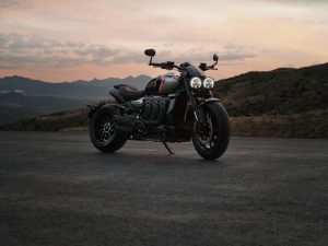 Triumph Rocket 3 Storm R 2027 – Seitenansicht auf einer Bergstraße in der Abenddämmerung