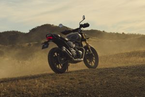 Triumph Scrambler 400 X 2027 – Seitenansicht auf einem trockenen Feld im Abendlicht