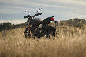 Triumph Scrambler 400 X 2027 – Dreiviertel-Frontansicht im hohen Gras