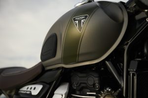 Triumph Scrambler 400 X 2027 – Detailansicht des Tanks mit Matt-Khaki-Green-Streifen und Triumph-Dreieck