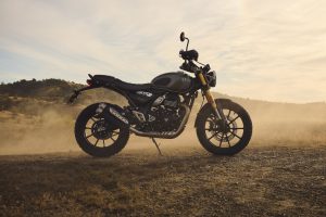 Triumph Scrambler 400 X 2027 – Seitenansicht auf staubiger Piste im Abendlicht