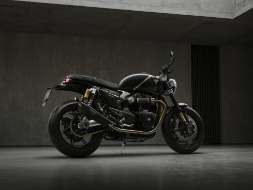 Triumph Speed Twin 1200 TFC 2027 – rechte Heckperspektive im Betonstudio mit Akrapovič-Schalldämpfer, goldener Antriebskette und Öhlins-Federbein