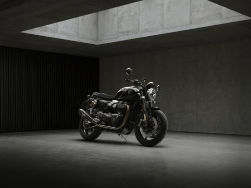 Triumph Speed Twin 1200 TFC 2027 – rechte Frontperspektive im Betonstudio, Gesamtansicht mit rundem LED-Scheinwerfer und Lenkerendspiegeln