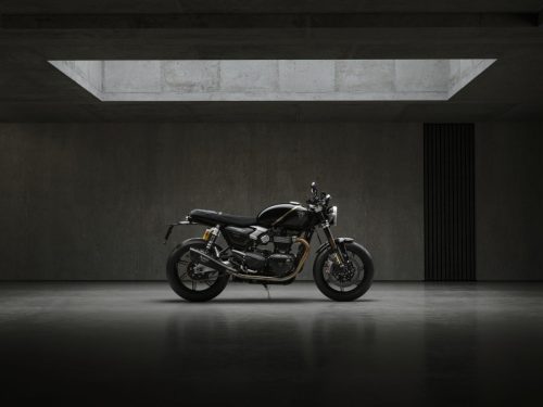 Triumph Speed Twin 1200 TFC 2027 – linke Seitenansicht im Profil im Betonstudio mit goldenem Öhlins-Federbein und Akrapovič-Schalldämpfer