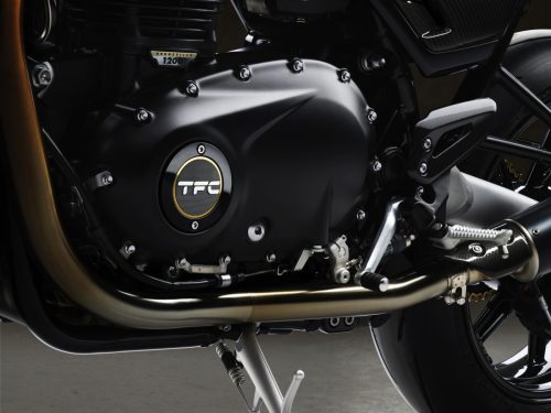 Triumph Speed Twin 1200 TFC 2027 – Motordetail mit Bonneville-1200-HP-Emblem, goldgerahmtem TFC-Deckel, bronzefarbenen Krümmern und goldener Kette