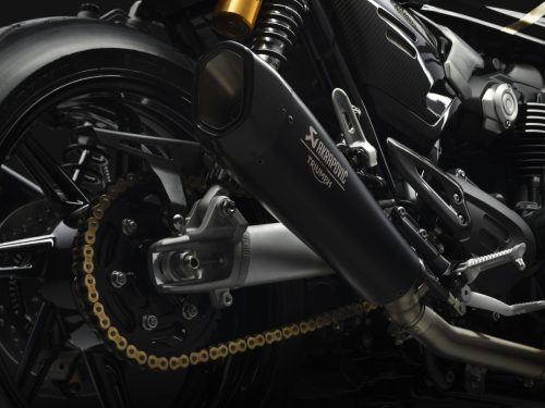 Triumph Speed Twin 1200 TFC 2027 – Detail des Akrapovič-Schalldämpfers mit goldener Kette, hinterem Kettenrad und Öhlins-Federbein