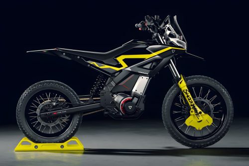 Ultraviolette Shockwave – Rechte Seitenansicht in Cosmic Black mit sichtbarem PMSM-Elektromotor, Batterie-Einheit, Kettenantrieb und gelber Telegabel auf gelbem Montageständer