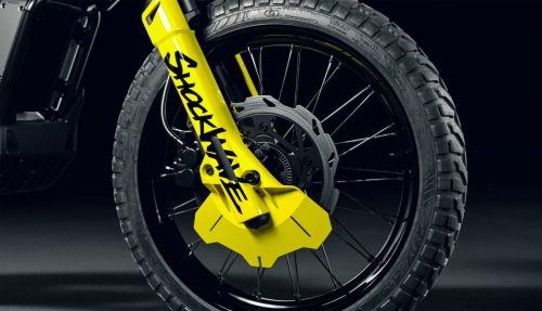 Ultraviolette Shockwave – Detailansicht der gelben 37-mm-Telegabel mit Shockwave-Schriftzug, 270-mm-Scheibenbremse und 19-Zoll-Speichenrad mit Offroad-Bereifung, Cosmic Black, Weitwinkel