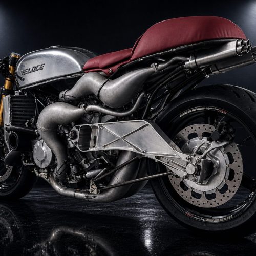 Veloce Aperion 2026 – Linke Seitenansicht Studioaufnahme mit poliertem Aluminiumtank und Veloce-Schriftzug, rotem Sitz, freiliegenden Expansionskammern und Gitterrohr-Schwinge auf dunklem Hintergrund