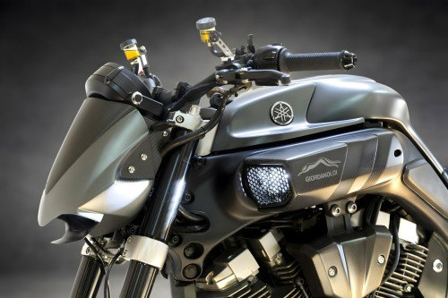 Yamaha MT-01 ORCO – Frontansicht bei Nacht mit leuchtenden Doppelscheinwerfern und vier LED-Positionslichtern, dramatische Silhouette