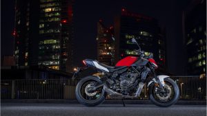 Yamaha MT-07 Y-AMT 2027 – in Redline, Seitenansicht vor beleuchteten Hochhäusern