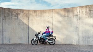 Yamaha XSR900 2027 – Fahrer sitzt auf der XSR900 in Neon White vor einer geschwungenen Betonwand