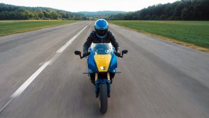 Yamaha XSR900 GP 2027 – Frontalansicht in Legend Blue auf einer langen Geraden mit Mittelmarkierung