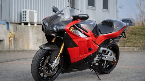 Yoshimura Tornado S-1 – Schräge Frontansicht auf Hof vor Industriegebäude mit japanischem Yoshimura-Schriftzug und goldener Öhlins-Gabel (Poland-Exemplar Nr. 21)